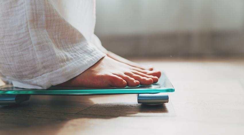 Female feet standing on electronic scales for weight control