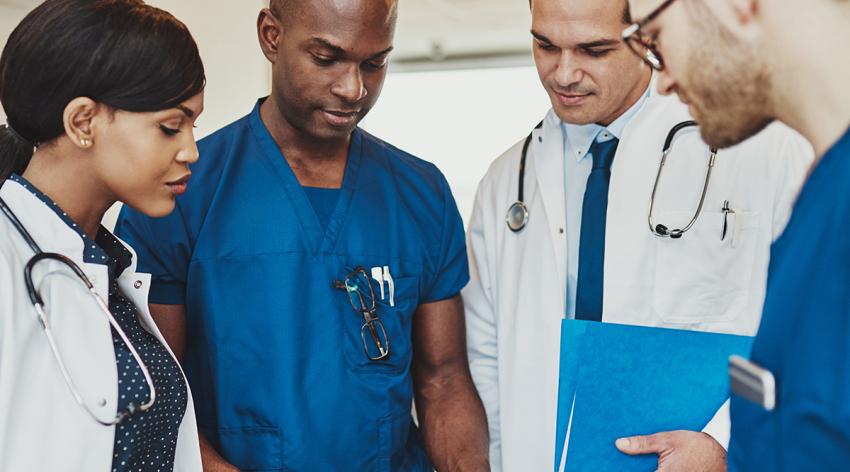 Group of multiracial doctors standing consulting patient records