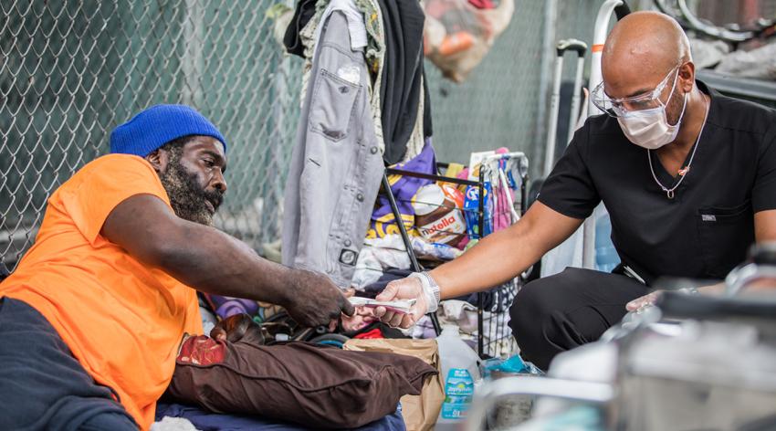 Hansel Tookes, MD, MPH, exchanges sterile needles for used ones as part of a University of Miami Leonard M. Miller School of Medicine harm reduction effort.