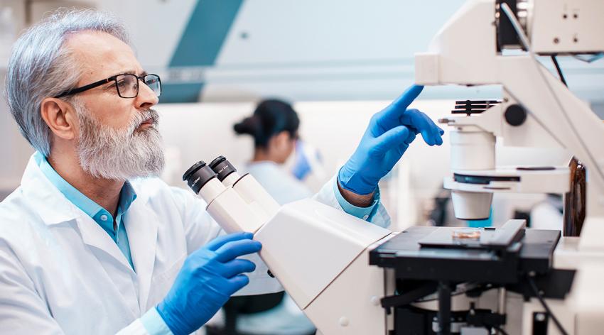 Male scientist working in the lab using a microscope