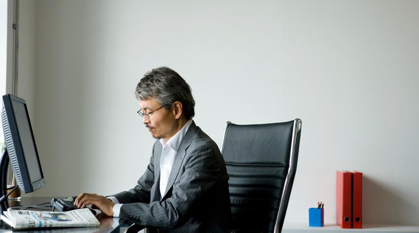 Mature businessman typing on keyboard