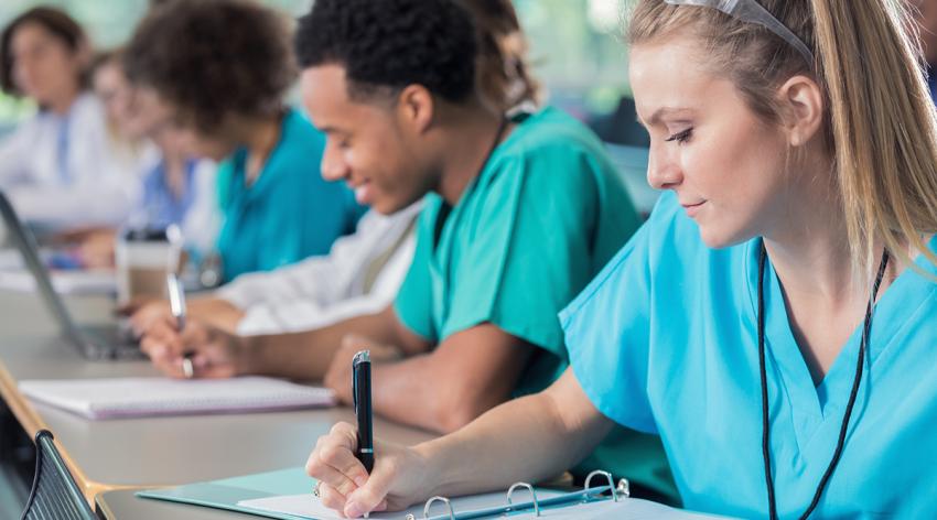 Focused medical students take notes during lecture