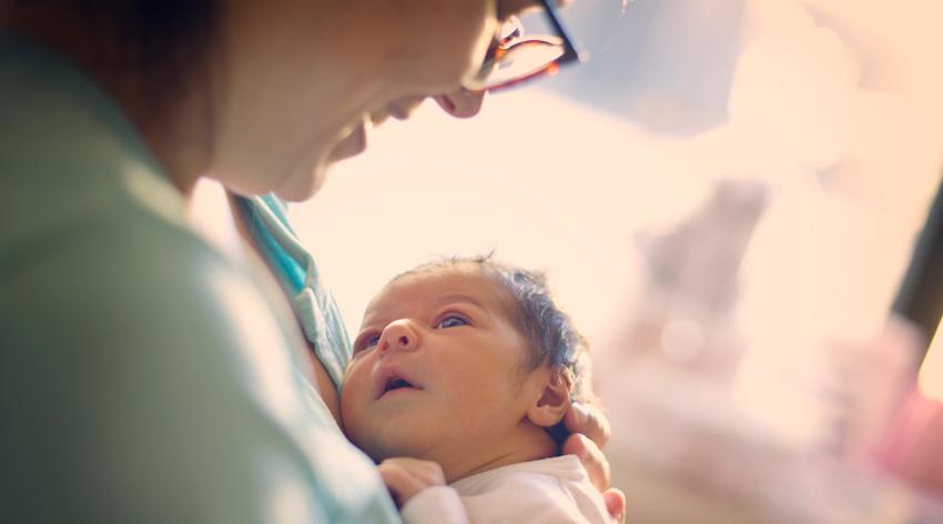 Mom smiling at newborn at hospital