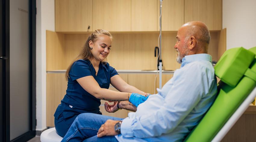 A nurse collecting patient's blood sample in medical clinic