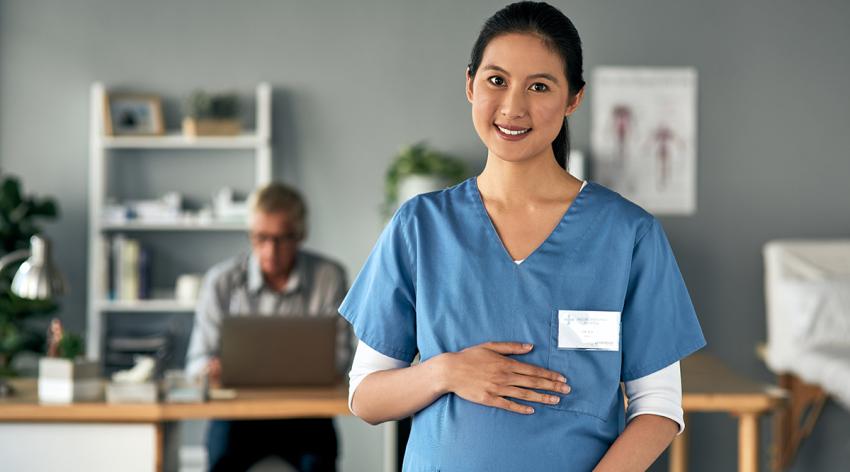 A pregnant medical practitioner standing in a modern office