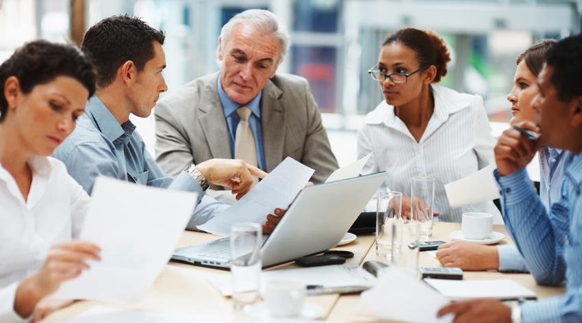 Business people discussing work on laptop at a meeting