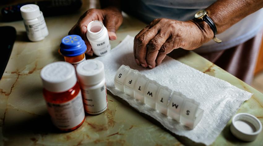 Senior woman sorting weekly medication