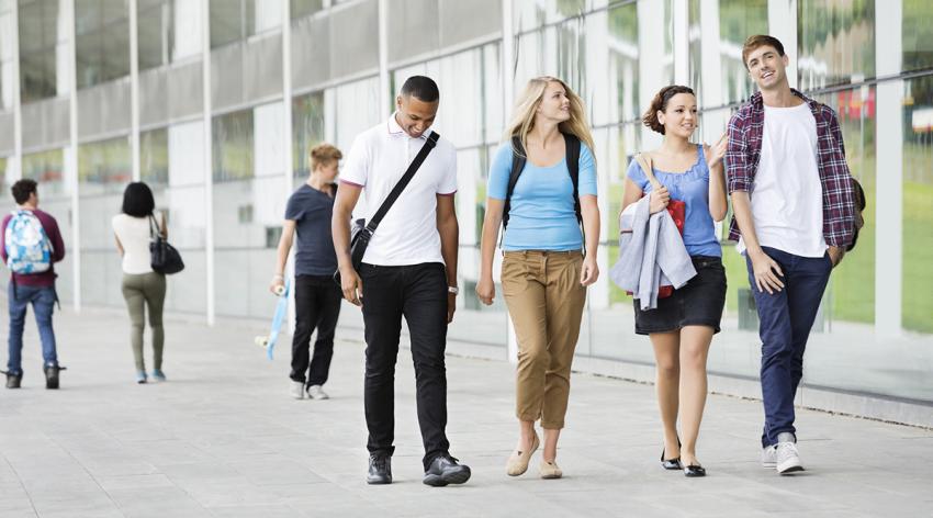 four students walk across campus