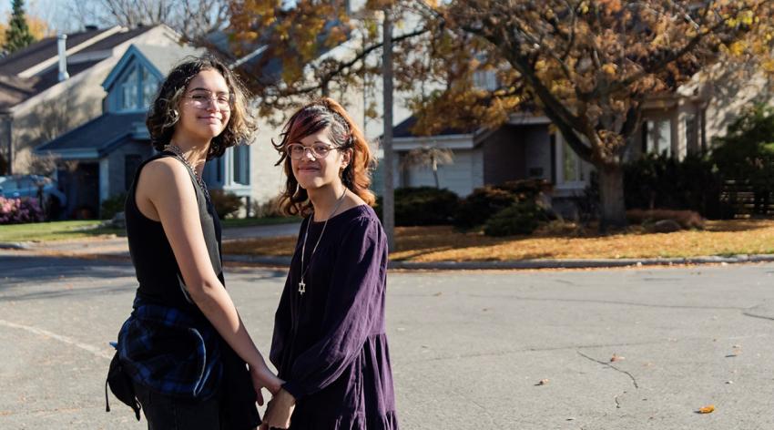 Transgender girl and non-binary teen friends portrait walking in suburb street on a warm day in autumn.
