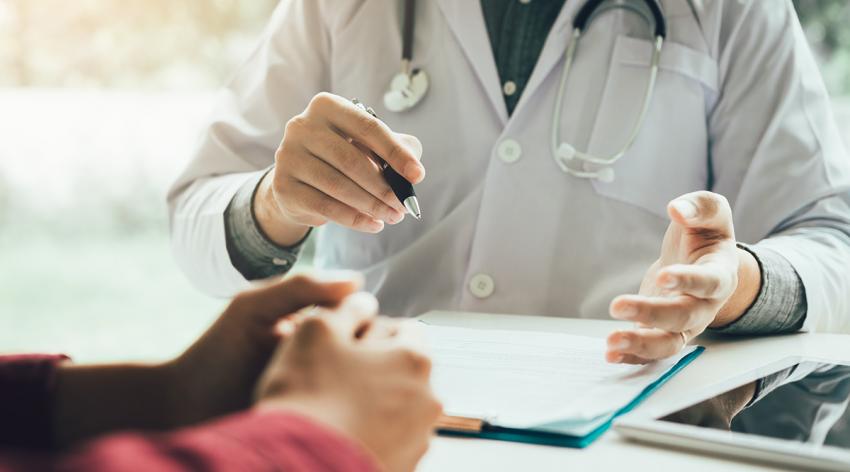 Hands of a patient and a doctor on a table