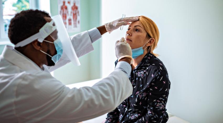 A woman receives a swab test from a medical provider