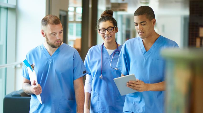 Young doctors wearing scrubs walking down the hallway