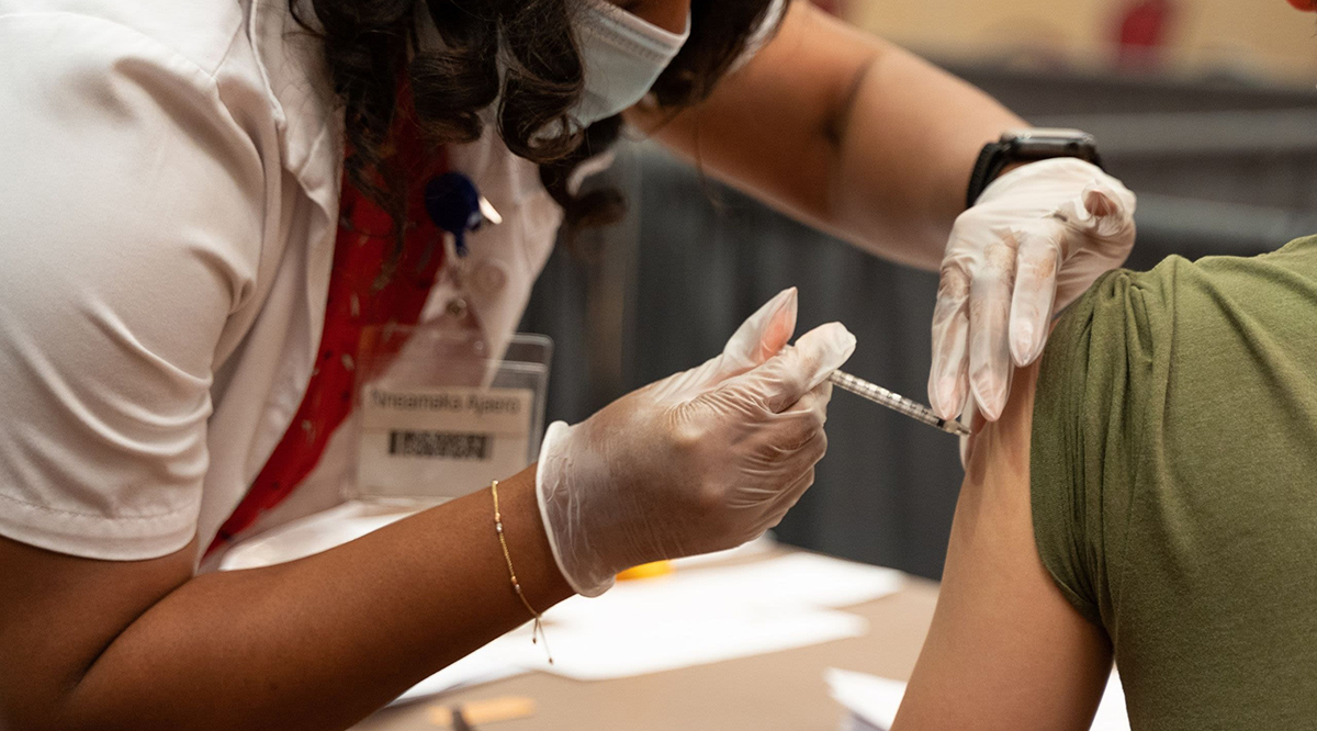 A nurse injecting vaccine into a patient's arm