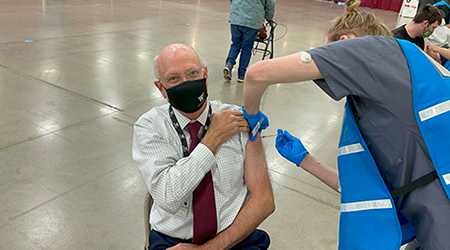 Founding Dean of Western Michigan University, Dr. Hal B. Jenson, received his first dose of the COVID-19 vaccine from M2 Koby Buth during vaccination clinic at the Kalamazoo County Expo Center.