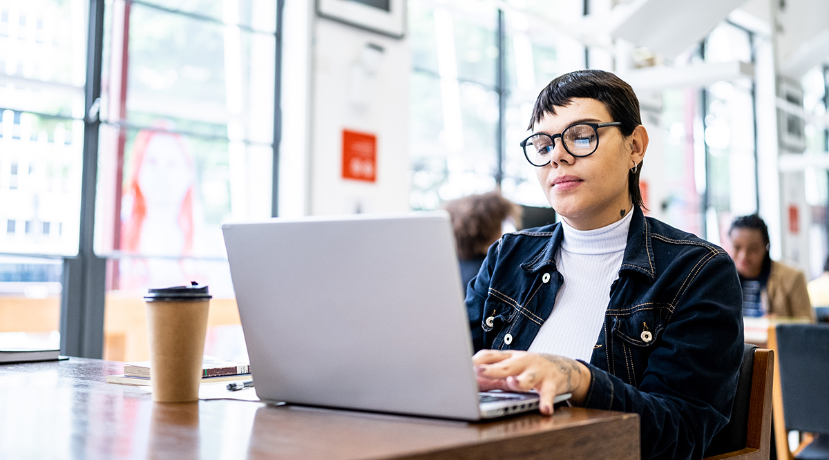 Transgender woman using the laptop in the library