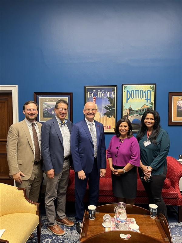 leaders standing in front of couch with posters on wall