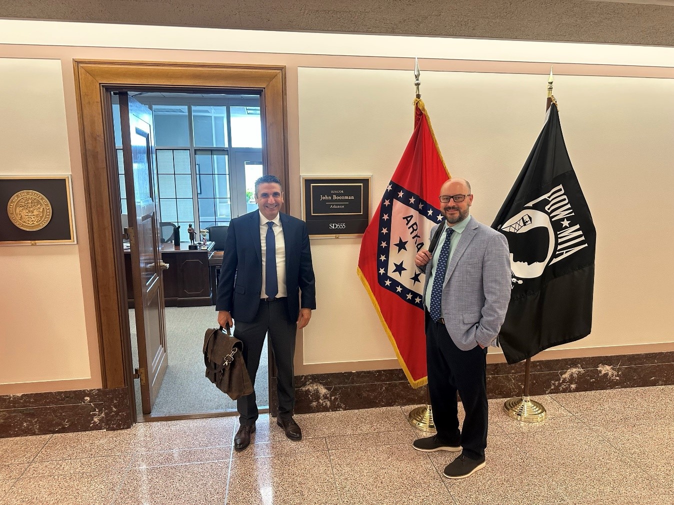 men standing in front of flags in hallway