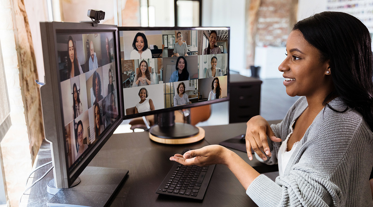 Woman gestures during virtual meeting with colleagues
